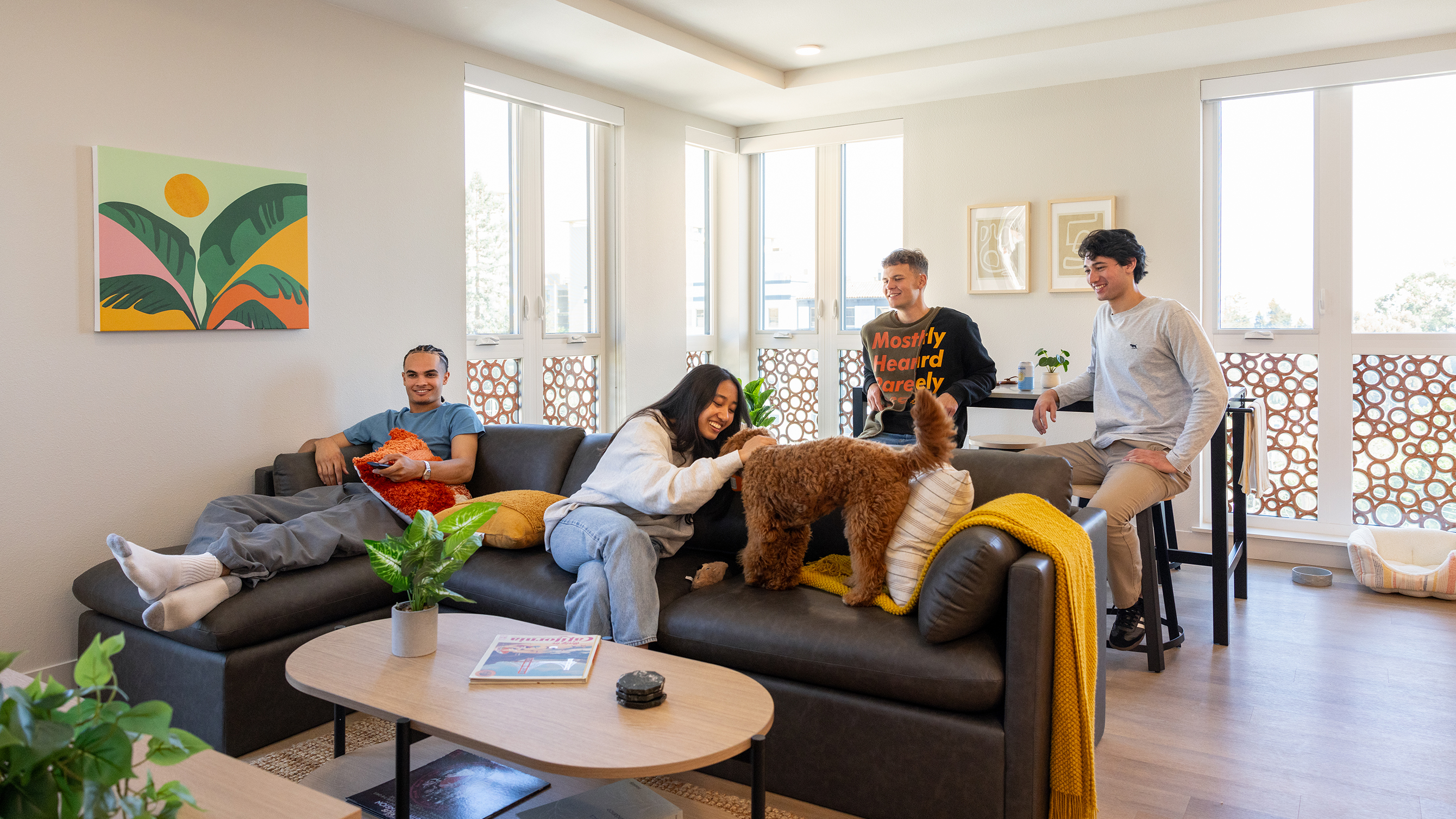 People petting a dog on a couch